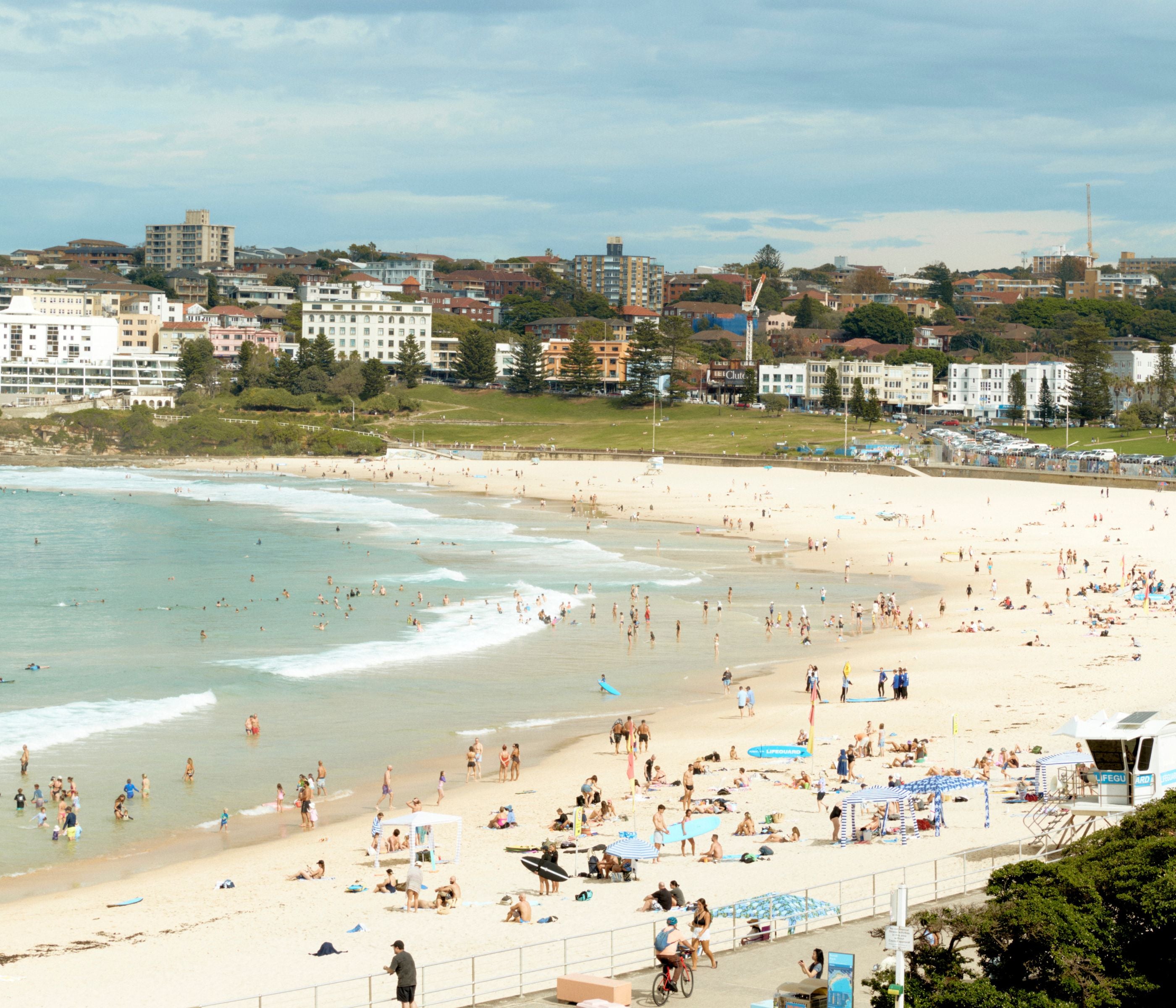 Bondi Beach, with swimmers and the suburb behind